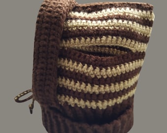 May include: A brown and beige striped crocheted hat with a brown brim and a drawstring.