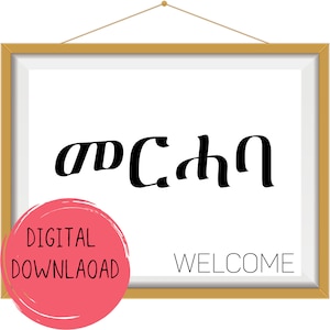 May include: A framed printable with the text "Welcome" in English and "መ ር ሓ ባ" in Amharic. The frame is gold with a white mat. The printable has a pink circle with the text "Digital Download" in white.