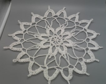 Könnte beinhalten: Weiße gehäkelte Tischdecke mit einem zarten Blumenmuster.
