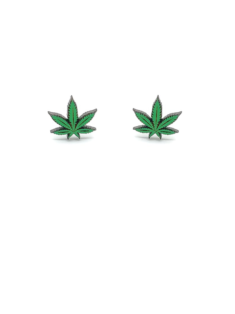 May include: A pair of small, silver-toned earrings with green marijuana leaf designs.