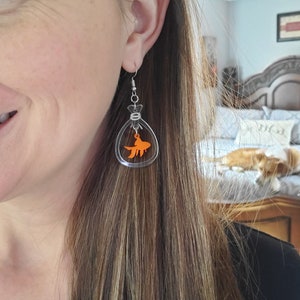 May include: Clear acrylic earrings with a small orange goldfish inside each earring.