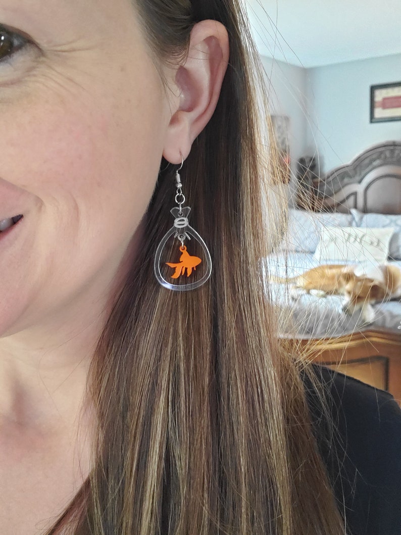 May include: Clear acrylic earrings with a small orange goldfish inside each earring.