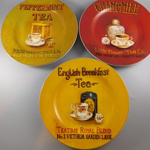 May include: Three yellow and red ceramic plates with tea-themed designs. The plates feature illustrations of teacups, teapots, and tea boxes. The text on the plates reads "Peppermint Tea", "Chamomile", and "English Breakfast Tea".