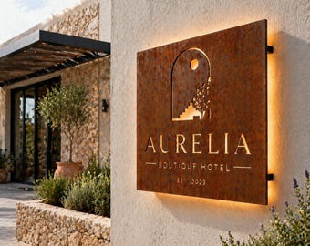 Könnte beinhalten: Ein rechteckiges Schild aus rostigem Metall mit hinterleuchteter Schrift und ausgestanztem Design. Das Schild zeigt den Text AURELIA, BOUTIQUE HOTEL und EST 2023. Der Ausschnitt zeigt einen Torbogen, eine Sonne, Treppen und einen Baum.