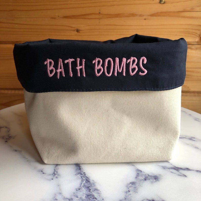 Cream canvas organiser with navy overturn with bath bombs embroidered onto it, in a colour of your choice