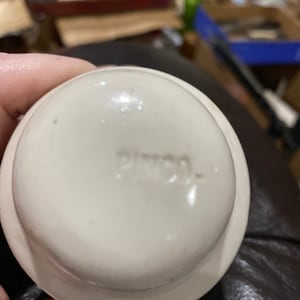 Peut inclure: Bouchon de bouteille en céramique blanche avec le mot "PYREX" en relief sur le dessous.