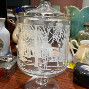 Bonito cuenco de pedestal de vidrio con diseño pintado en blanco.