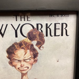 Puede incluir: Una portada vintage de la revista The New Yorker del 8 de diciembre de 2003, que presenta una ilustraci&oacute;n de dibujos animados de una mujer con una expresi&oacute;n de frustraci&oacute;n. La mujer tiene el pelo casta&ntilde;o atado hacia atr&aacute;s con una diadema de estampado de leopardo y lleva un top negro sin mangas.