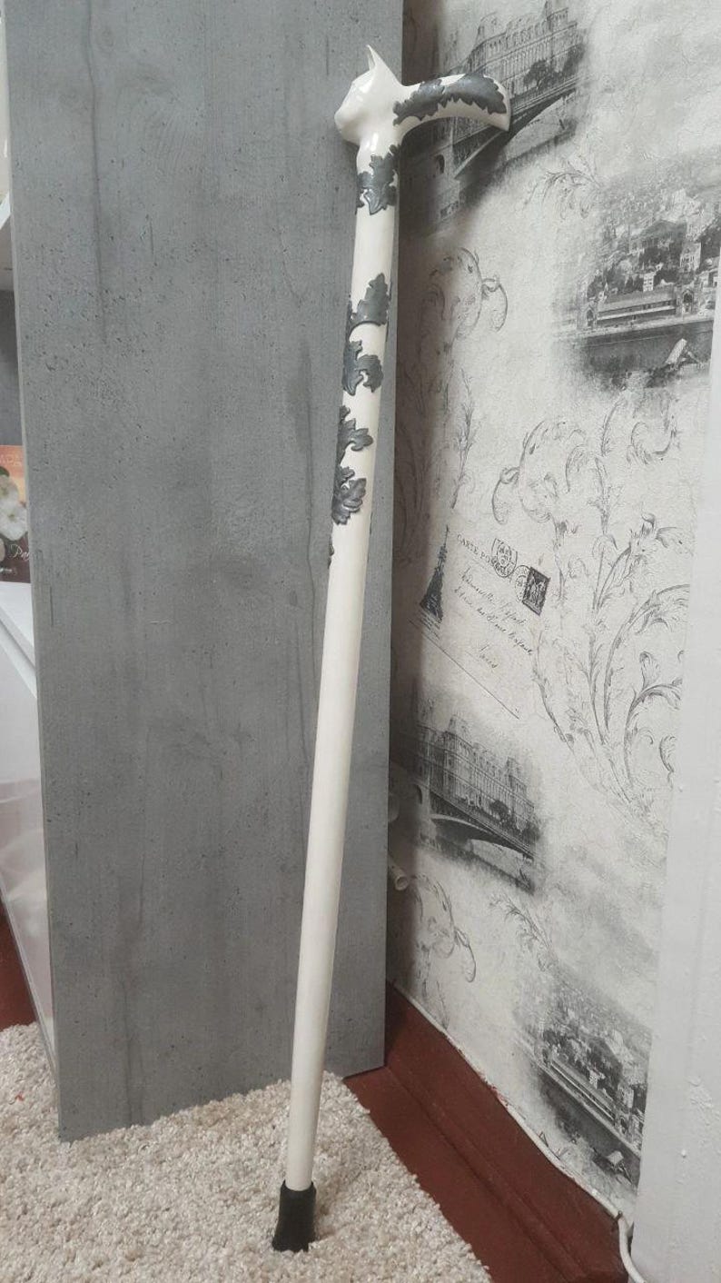 Pu&ograve; includere: Bastone bianco con manico a forma di gatto. Il manico e gli elementi decorativi sull'asta sono dipinti di grigio. Il bastone &egrave; lungo circa 91 cm, con un puntale in gomma nera per la stabilit&agrave;.