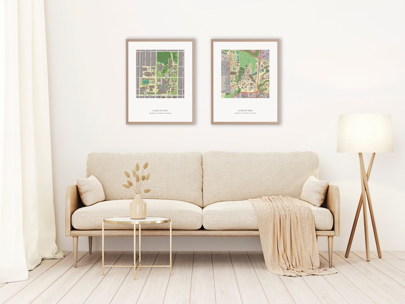 May include: Two framed maps of a university campus, hanging on a white wall above a beige couch with a throw blanket. The maps are labeled "Class of 2023" and "Class of 2024".