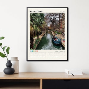 May include: A poster with a black frame featuring a photograph of the River Walk in San Antonio, Texas. The poster includes the text "SAN ANTONIO" and "Texas, USA". The text below the image describes the history of the city and its attractions.