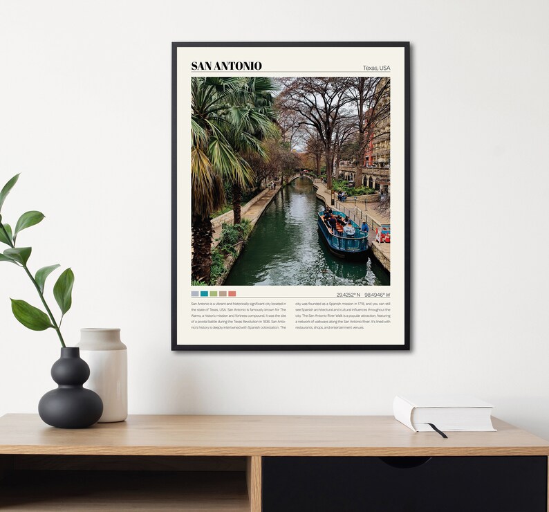 May include: A poster with a black frame featuring a photograph of the River Walk in San Antonio, Texas. The poster includes the text "SAN ANTONIO" and "Texas, USA". The text below the image describes the history of the city and its attractions.