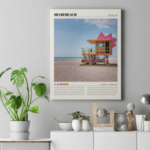 May include: A vintage-style poster featuring a pink and green lifeguard stand on a sandy beach with a blue sky and white clouds. The poster has the text "Miami Beach, Florida USA" and coordinates "25.7600&deg; N, 80.1300&deg; W".