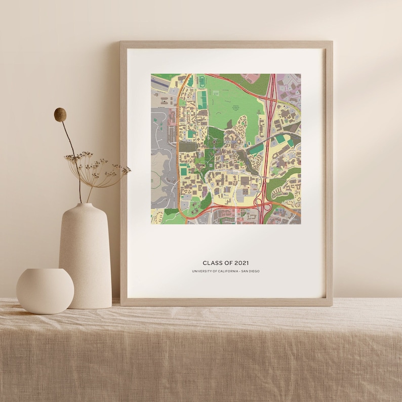 May include: A framed print of a map of the University of California, San Diego campus. The map is in a light brown frame and has a white background. The text "CLASS OF 2021" and "UNIVERSITY OF CALIFORNIA, SAN DIEGO" is printed below the map.