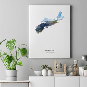 May include: A watercolor print of the outline of Nova Scotia, Canada, with a blue and green color scheme. The print is on a white background and includes the text "NOVA SCOTIA 44.6529&deg; N, 63.5877&deg; W".