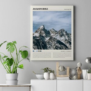 May include: A vintage-style poster with a photograph of snow-capped mountains in Jackson Hole, Wyoming, USA. The poster has a minimalist design with the text "JACKSON HOLE" and "Wyoming, USA" in a sans-serif font. The poster also includes the coordinates "43.4789&deg; N, 110.7066&deg; W".