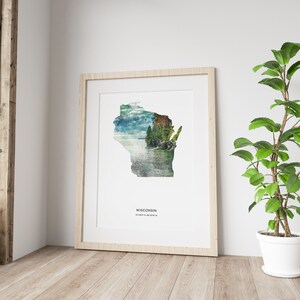 May include: A framed print of the state of Wisconsin with a scenic landscape image inside the outline of the state. The text "WISCONSIN" and the coordinates "43.0747&deg; N, 89.3841&deg; W" are printed below the image.