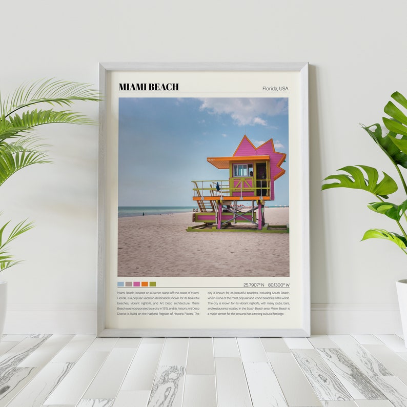 May include: A colorful lifeguard stand on a sandy beach in Miami Beach, Florida. The stand is painted pink, green, and orange. The text "Miami Beach, Florida, USA" and "25.7907&deg; N 80.1300&deg; W" is printed below the image.