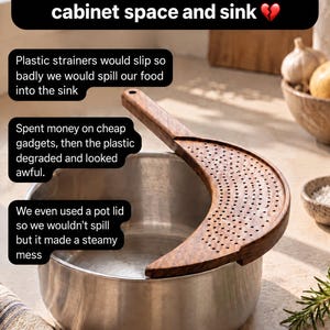 May include: A crescent-shaped wooden strainer with a perforated surface and a handle, positioned over the rim of a stainless steel pot. The image includes text overlays discussing kitchen storage and the utility of the wooden strainer.