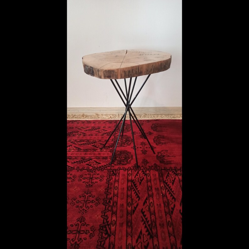 Puede incluir: Una mesa de madera con una tapa de madera natural y una base de metal negro. La mesa tiene un aspecto r&uacute;stico y es perfecta para un espacio peque&ntilde;o.
