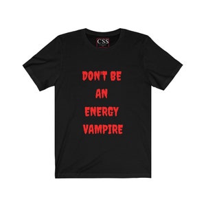 May include: Black t-shirt with the text "DON'T BE AN ENERGY VAMPIRE" in red.