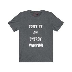 May include: A dark heather grey t-shirt with the text "Don't be an energy vampire" printed in white.