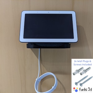 Peut inclure: Écran intelligent Google Nest Hub Max blanc monté sur un mur avec un câble blanc et un cordon blanc enroulé sur le mur. Le texte sur le mur indique "2x Wall Plugs & Screws Included".