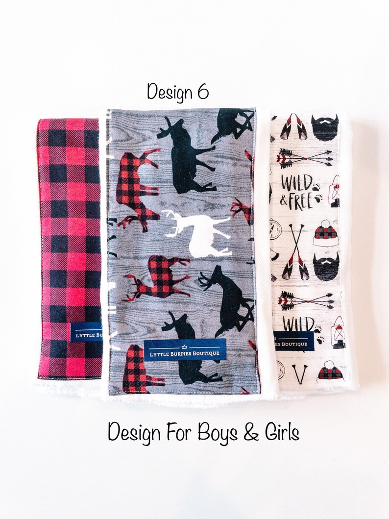 May include: Three fabric burp cloths with different designs. The first cloth is red and black plaid. The second cloth has a gray background with black and white deer silhouettes and red and black plaid accents. The third cloth has a white background with a brown beard, arrows, and the text "Wild & Free".