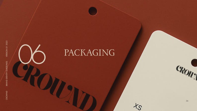 May include: Close-up of two rectangular tags. One is a deep red-brown color with the word "PACKAGING" in white text. The other tag is off-white with the word "CROWN" printed in black. The tags have a hole at the top.