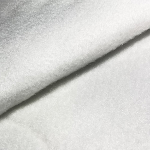 May include: Close-up of a white fleece fabric with a soft, fuzzy texture.