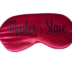 May include: Red satin sleep mask with the text "Master's Slave" in black glitter.
