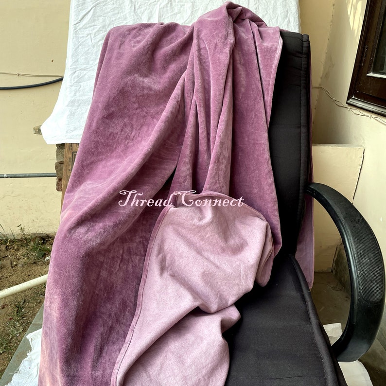Pu&ograve; includere: Un tessuto di velluto rosa polveroso drappeggiato su una sedia nera. Il tessuto ha un aspetto morbido e strutturato con aree pi&ugrave; chiare, creando un look vintage. Il testo "Thread Connect" &egrave; visibile sul tessuto.