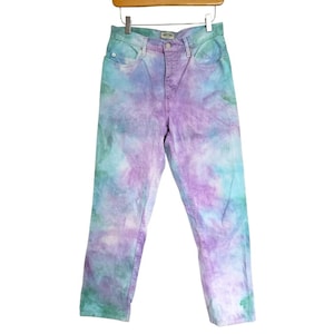 May include: A pair of light blue jeans with a tie-dye pattern in shades of purple, pink, and green.