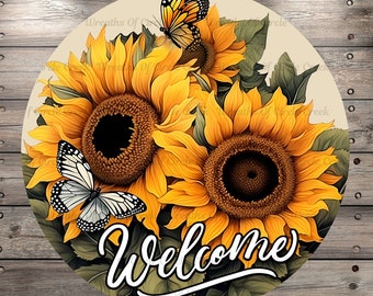 Op de afbeelding: Rond bord met zonnebloemen en vlinders. De zonnebloemen zijn geel en bruin, met groene bladeren. Twee vlinders, een oranje en zwarte, de andere wit en zwart, zitten op de bloemen. Het woord "Welcome" is in witte letters geschreven.