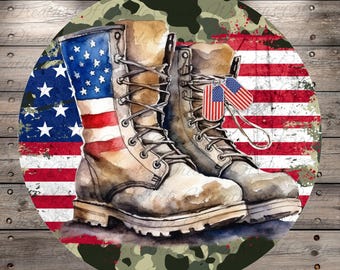 May include: Round decorative sign featuring a watercolor illustration of combat boots. The boots are adorned with the American flag and small flags. The background includes a camouflage pattern and a distressed American flag.