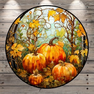 May include: A stained glass style round rug with a fall theme. The rug features three pumpkins in shades of orange and yellow surrounded by green and brown leaves.