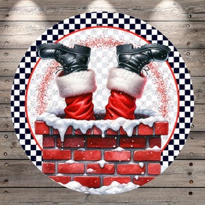 May include: A round Christmas-themed design featuring Santa's legs and boots sticking out of a brick chimney. The boots are black, the socks are red with white fur trim, and the chimney is red brick. The design has a red and black checkered border.