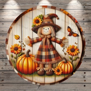 May include: A round wooden sign featuring a scarecrow with a plaid dress and hat, sunflowers, and pumpkins. The sign has a rustic design with a wooden background and a plaid border. The text "Circle Creek Wreaths Of" is visible.