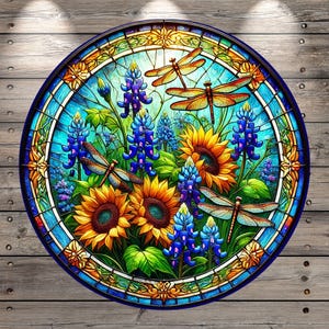 May include: A stained glass round art piece featuring bluebonnets, sunflowers, and dragonflies. The artwork is set against a blue and green background with a yellow border.