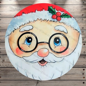 May include: A close-up of a Santa Claus face with a white beard and red hat. The Santa has blue eyes and is wearing black-rimmed glasses. The background is a wooden surface.
