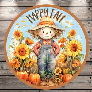 May include: A watercolor illustration of a scarecrow standing in a field of sunflowers. The scarecrow is wearing a red and white plaid shirt, blue overalls, and a straw hat. The sunflowers are in bloom and have yellow petals and brown centers. The background is a blue sky with white clouds. The text "Happy Fall" is written in brown letters at the top of the image.
