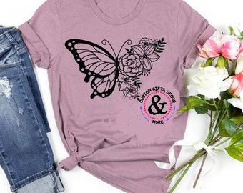 Könnte beinhalten: Ein mauvefarbenes T-Shirt mit einem schwarzen Schmetterling und einem Blumendesign. Das Shirt trägt den Text "Custom Gifts & Decor More" in einem Kreis.
