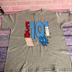 Puede incluir: Camiseta gris con un número 10 azul, el nombre Elijah en letras rojas y personajes de dibujos animados de un lápiz, una goma de borrar y el número 4.