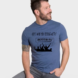May include: A blue t-shirt with a black graphic that says "Hey!! Who you riding with? MUDDMAN" with a silhouette of five people raising their hands in the air.