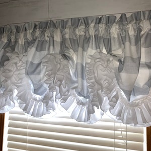 May include: A gray and white gingham valance with white ruffles. The valance is made of a soft, lightweight fabric and is perfect for adding a touch of farmhouse style to any window.