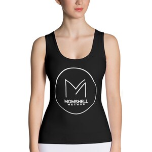 Peut inclure: Top de sport noir avec un logo circulaire blanc qui dit "Momshell Method" et un "M" stylisé à l'intérieur du cercle.