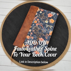 May include: A brown faux leather spine add-on for a book cover. The cover features a floral pattern with orange, white, and blue flowers on a dark blue background. The text "ADD-ON Faux Leather Spine To Your Book Cover" is visible in the image.