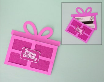 May include: Pink paper gift card holder with a cut-out design of a gift box and bow. The holder has a window to insert a gift card and says "Happy Birthday" on the front.