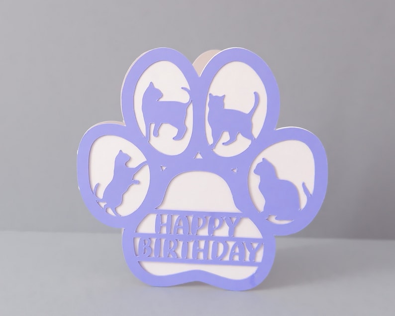 May include: Purple paw print card with cut-out cat silhouettes and the text "Happy Birthday".