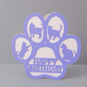 May include: Purple paw print card with four cat silhouettes and the text "Happy Birthday" inside.
